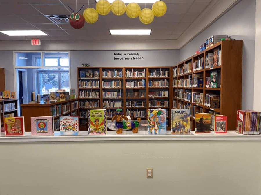 A colorful display of children's books and a puppy statue in a corner of the Innis Library branch.