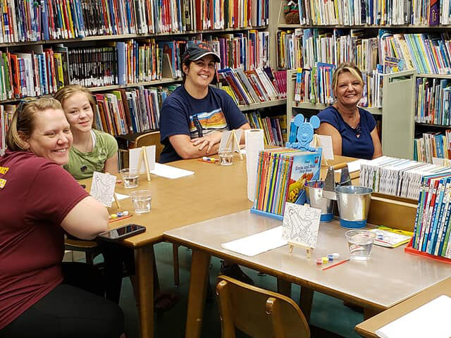 A group of smiling women participating at a Morganza library branch event.