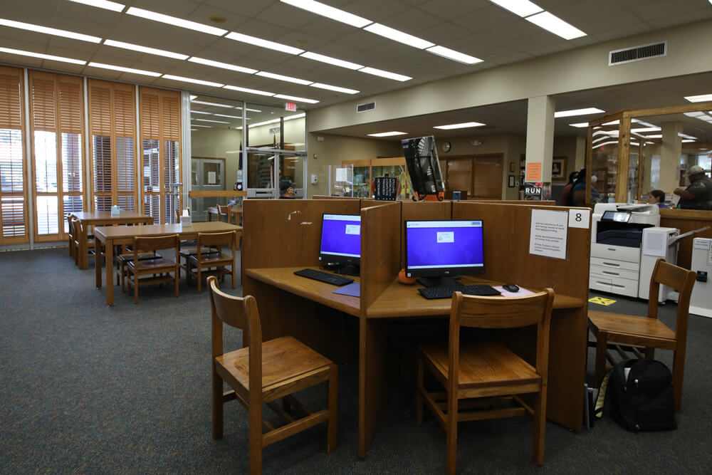 Carrel desk with computers with access to online library resources in the library center.