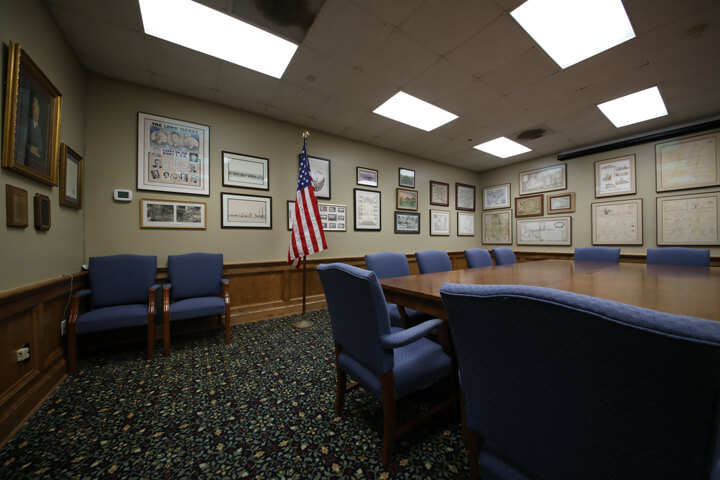 A Pointe Coupee library meeting room in New Roads with a conference table setup and cozy blue armchairs.