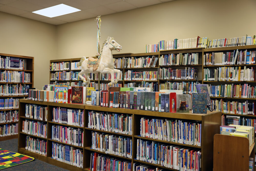 A carousel horse statue sits atop a bookshelf in the kids' area of Pointe Coupee Parish Library's New Roads branch.